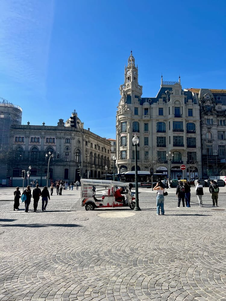 Aliados plaza in Porto on a sunny day, with a tuk tuk